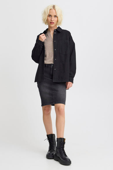 Zwart jeanshemd van PULZ, gedragen met een beige trui, een donkergrijze rok en zwarte laarzen.