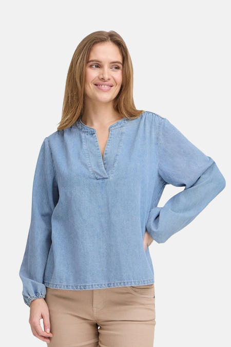 Blouse van denim door PULZ, met lange mouwen en een V-hals, gecombineerd met een khaki broek.
