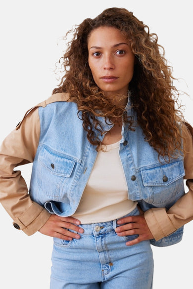 Jeansjas van lichtblauw denim van PULZ, met beige mouwen en metalen knopen, gedragen met een crèmekleurig shirt.
