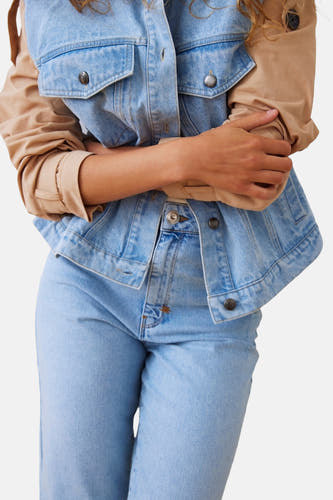 Jeansjas in lichtblauwe denim, van PULZ, met bruine mouwen en metalen knopen, cropped.
