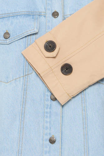 Lichtblauwe jeansjas van PULZ, met contrasterende beige mouwboorden en knoopsluiting.