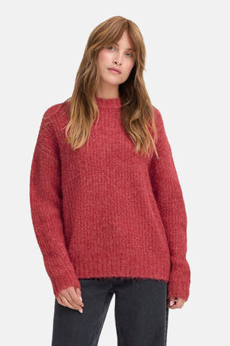 Rode trui met ronde hals van PULZ, met een grove gebreide textuur en lange mouwen, gedragen met een zwarte jeans.
