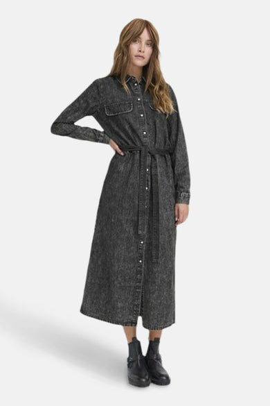 Donkergrijs denim kleedje met lange mouwen van PULZ, met knoopsluiting en ceintuur.
