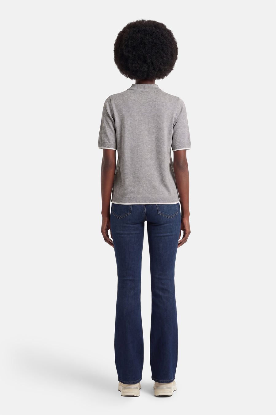 Pull gris à col rond de PULZ, coupe ajustée avec manches courtes et accents blancs, combiné avec un jean bleu foncé.