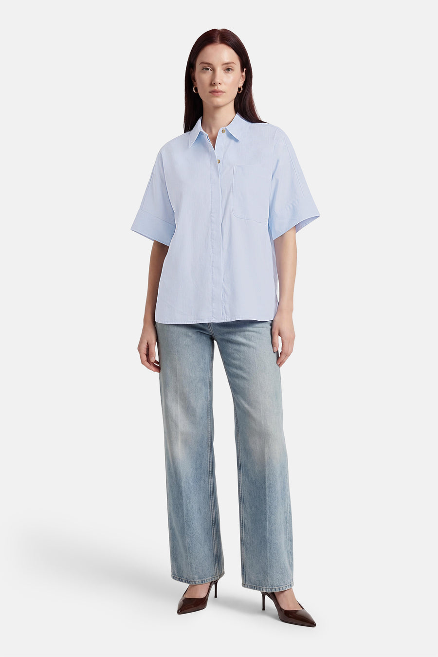 Blauw overhemd met korte mouwen van PULZ, met een borstzak, gedragen met jeans en hakken.