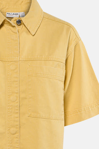 Geel jeanshemd van PULZ met korte mouwen, kraag, een drukknop en twee borstzakken, close-up.