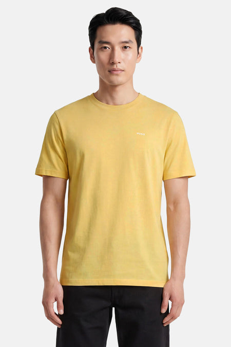 Geel T-shirt met korte mouwen van HUGO, met ronde hals en klein wit logo op de borst, gedragen door een man met zwarte broek.