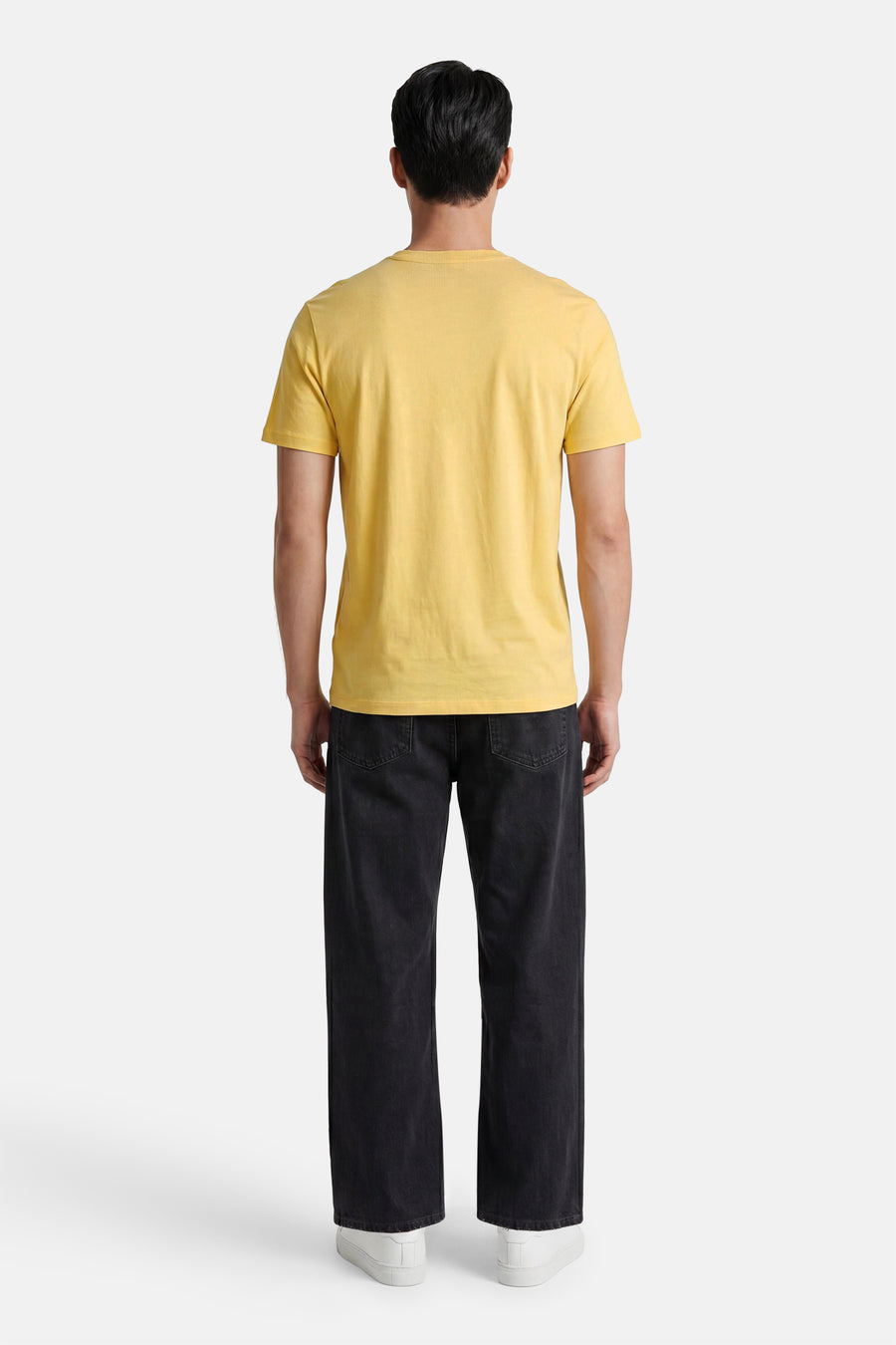 Geel T-shirt met korte mouwen van HUGO, achterkant, gedragen door een man met een zwarte jeans en witte sneakers.