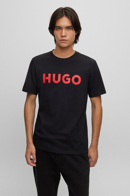 T-shirt noir à manches courtes de HUGO, avec des lettres rouges sur la poitrine.