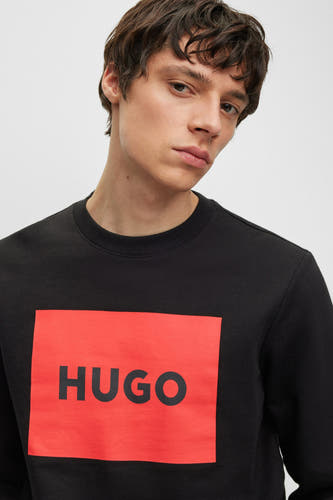 Gilet noir HUGO avec un carré rouge et le logo sur la poitrine.