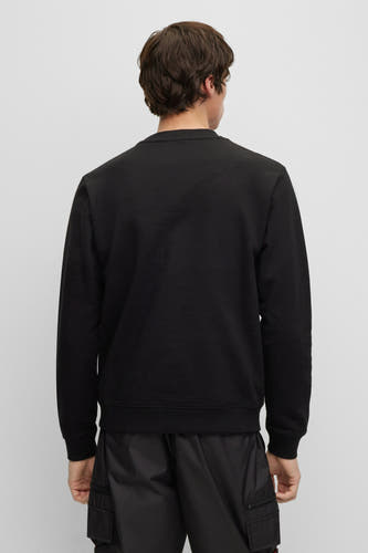 Pull-over noir avec col rond de HUGO, dos, associé à un pantalon noir.