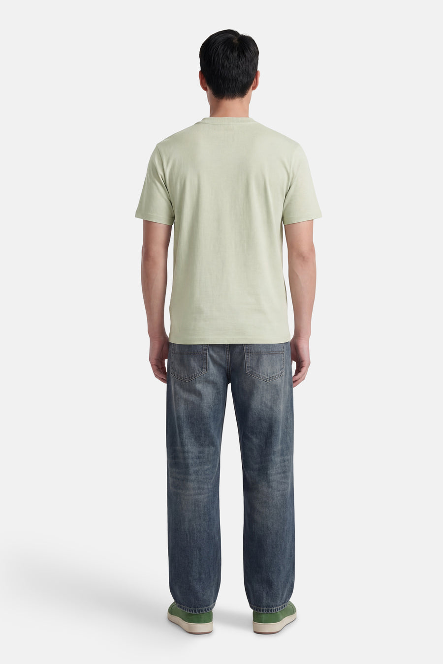 T-shirt vert à manches courtes de HUGO, dos d'un homme avec un jean foncé et des baskets vertes.