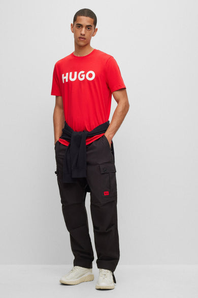 Grijze cargobroek van HUGO, gecombineerd met een rood T-shirt en een donkerblauw vest.