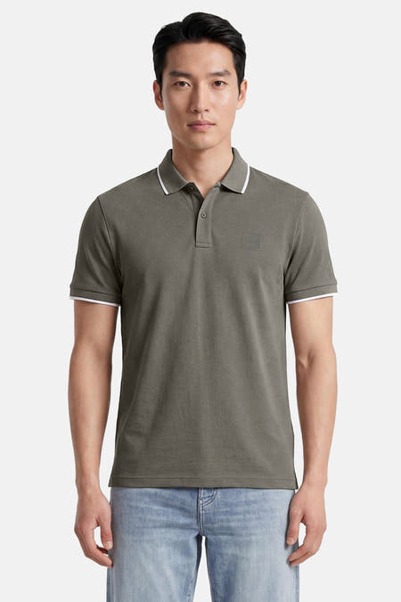 Kakikleurige polo van HUGO BOSS ORANGE met klassieke kraag, twee knopen, witte biezen en een ton-sur-ton BOSS-patch op de borst.