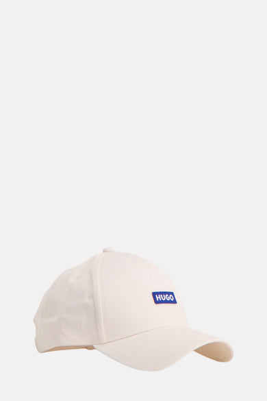 Chapeau blanc de HUGO BLUE, avec un étiquette logo bleu sur la'av.