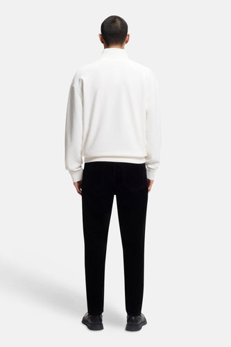 Witte sweater (ronde hals) van HUGO, gezien van achteren, gecombineerd met een zwarte broek en zwarte schoenen.
