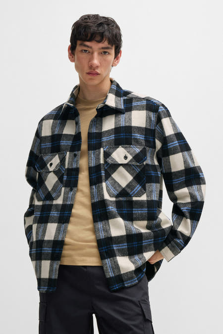 Zwart overhemd met lange mouwen van HUGO BLUE, met een ruitpatroon, gedragen over een beige shirt.

