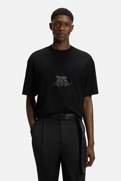 T-shirt noir à manches courtes de HUGO, avec une impression décorative sur la poitrine, associé à un pantalon noir et une ceinture.