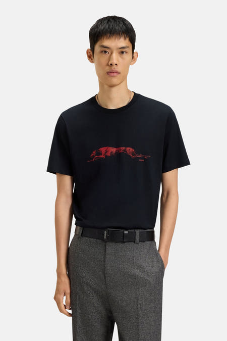 Zwart T-shirt met korte mouwen van HUGO, met rode hond print op de voorkant, gecombineerd met grijze broek en riem.