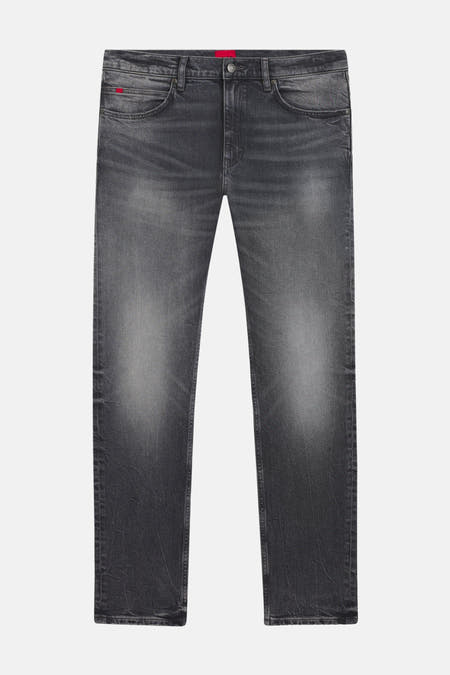 Jean gris coupe slim de HUGO, avec une finition délavée subtile et des détails de marque rouges.