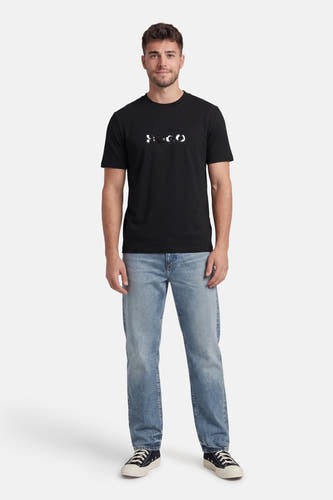 Zwart T-shirt met korte mouwen van HUGO, gedragen met blauwe jeans en zwarte sneakers.