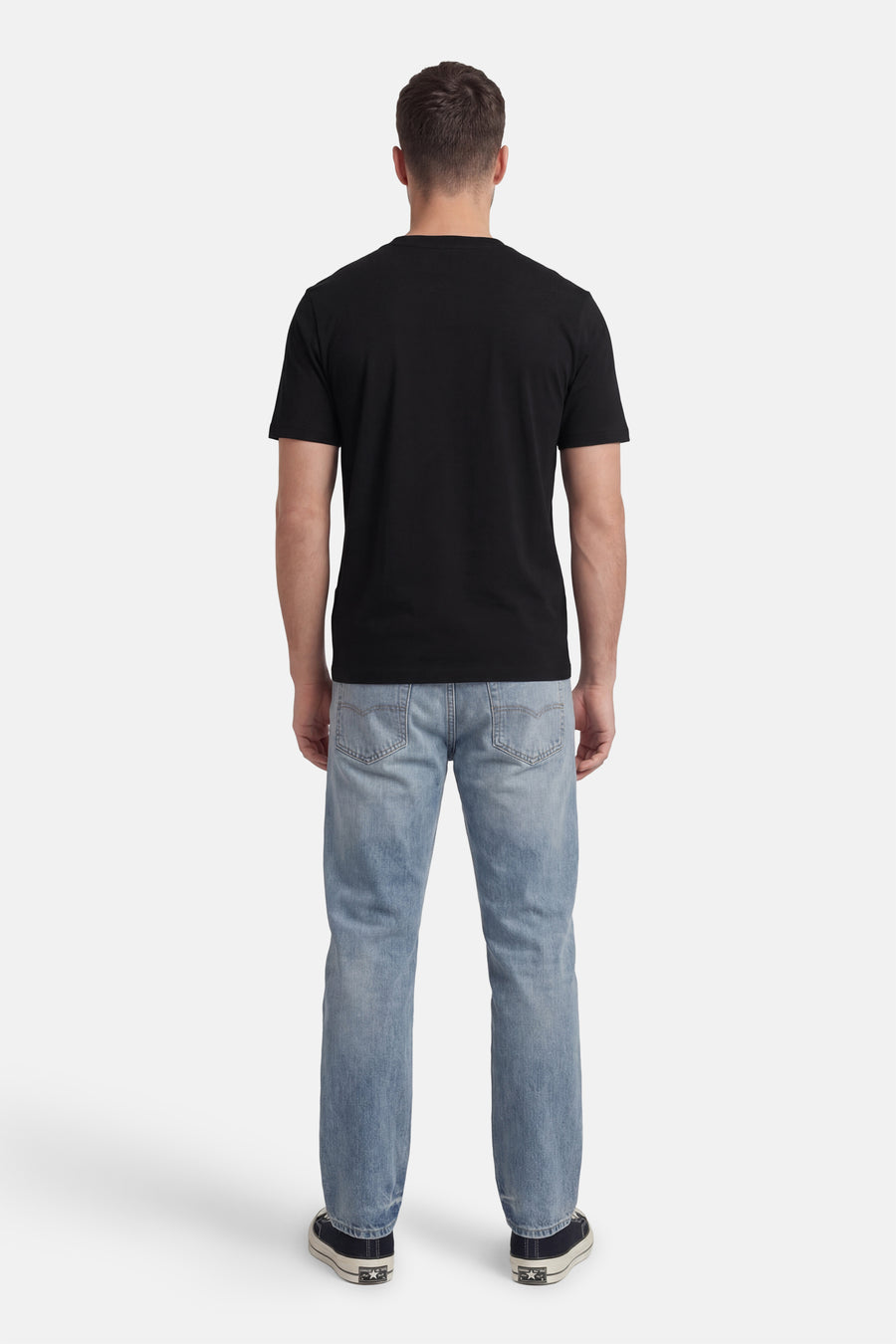 Zwart T-shirt met korte mouwen van HUGO, gezien van achteren, gecombineerd met blauwe jeans en donkere sneakers.
