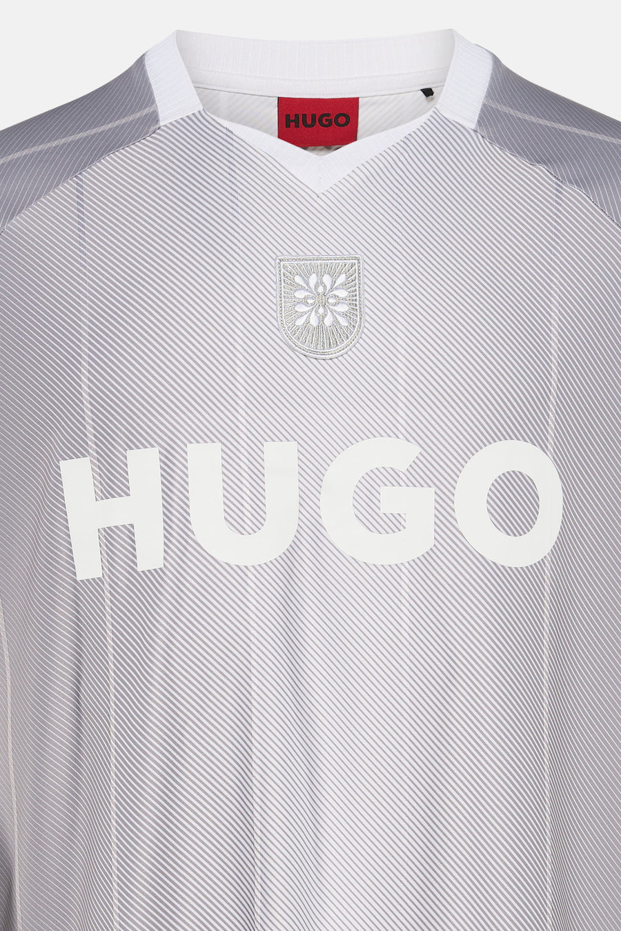 Lichtgrijs en wit gestreept T-shirt van HUGO met V-hals, geborduurd embleem en grote witte merkletters op de borst.