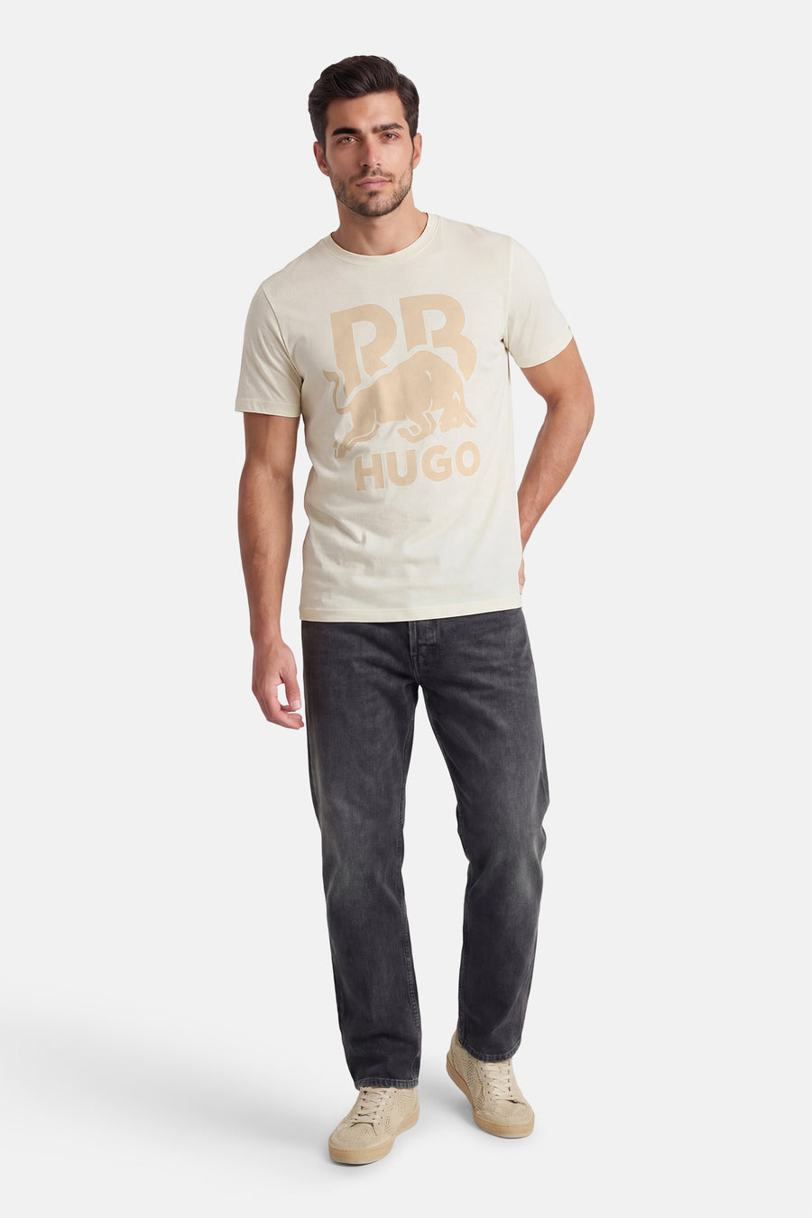 Ecru T-shirt met korte mouwen van HUGO, met een grafische print en gedragen met grijze jeans en crèmekleurige sneakers.
