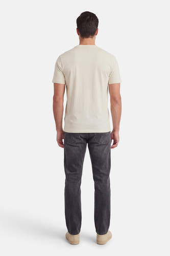 T-shirt écru à manches courtes de HUGO, vue de dos, combiné avec un jean foncé et des chaussures beiges.