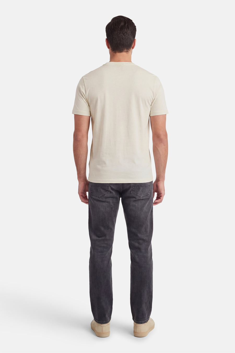 T-shirt écru à manches courtes de HUGO, vue de dos, combiné avec un jean foncé et des chaussures beiges.
