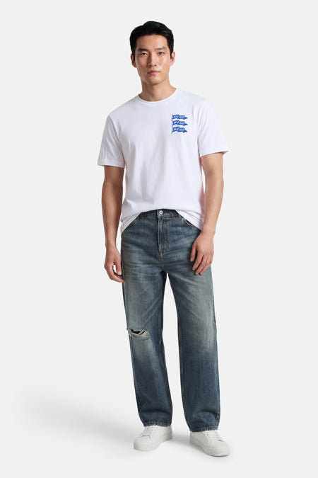 Wit T-shirt met korte mouwen van HUGO BLUE, met logo op de borst en gedragen met blauwe jeans en witte sneakers.
