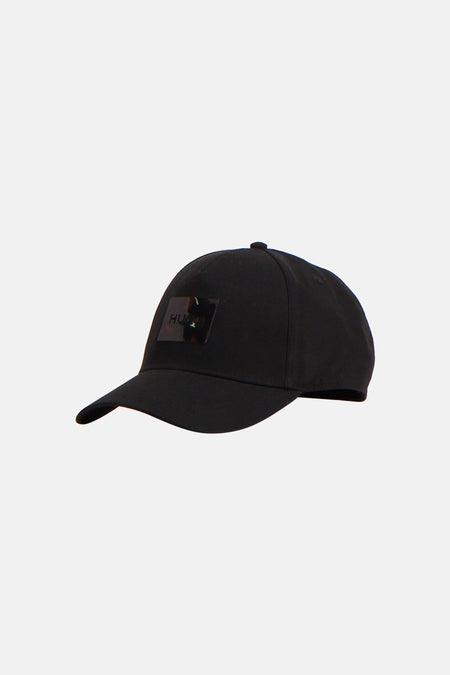 Zwarte pet van HUGO met glanzend logopatch op de voorkant, zijaanzicht.
