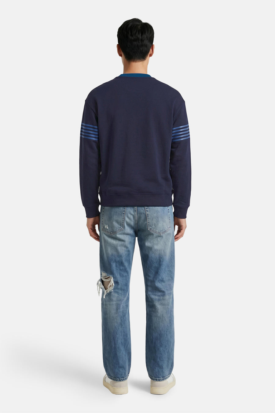Donkerblauwe ronde hals sweater van HUGO met blauwe strepen aan de mouwen, achterzijde weergegeven op model in versleten jeans.