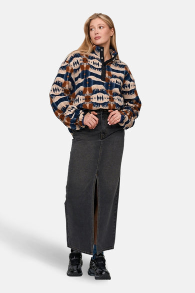 Multicolor fleece van 24 colours gmbh met een aztekenpatroon, gedragen met een lange spijkerrok en zwarte schoenen.
