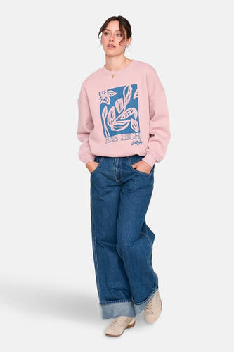 Gilet rose de 24 colours gmbh, avec une impression bleue de feuilles et le texte "Rise High", porté avec des jeans et des sneakers.