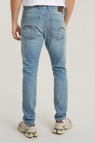 Jean skinny en denim bleu clair de G-Star RAW, avec des détails de poche arrière caractéristiques et des baskets crème.