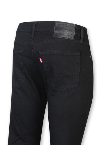 Jean slim fit noir de Levi's, avec une étiquette rouge sur la poche arrière et un patch en cuir sur la ceinture.