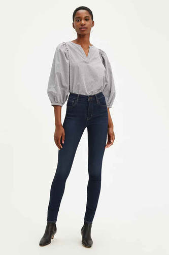 Jean skinny bleu marine de Levi's, porté avec une chemise à carreaux noir et blanc et des bottines noires.