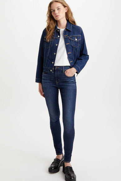 Donkerblauwe skinny jeans van Levi's, gecombineerd met een wit T-shirt en een donkerblauw spijkerjack.