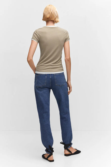 Olijfgroene korte mouwen T-shirt van MANGO, rugzijde, met witte bies aan kraag en mouwen, gedragen met blauwe jeans en zwarte sandalen.