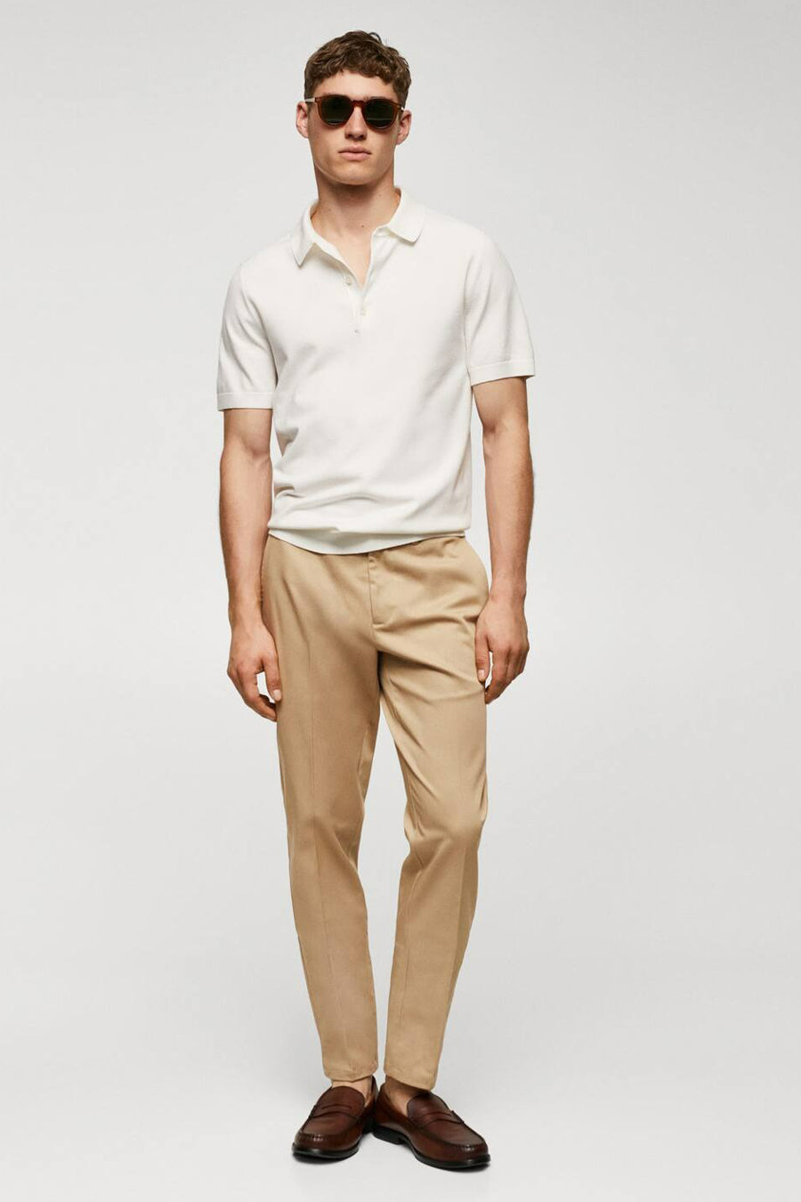 Jean chino marron de MANGO, avec poche arrière et passants, porté avec un T-shirt blanc.