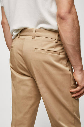 Bruine chino van MANGO, met achterzak en riemlussen, gedragen met een wit T-shirt.