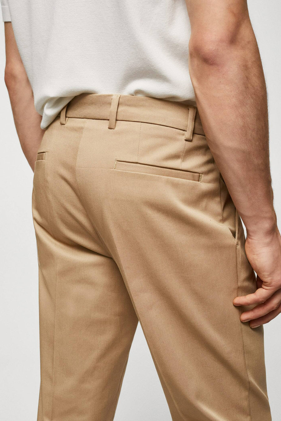 Bruine chino van MANGO, met achterzak en riemlussen, gedragen met een wit T-shirt.