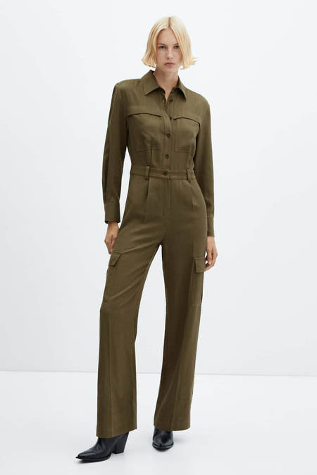 Groene jumpsuit van MANGO met lange mouwen, zakken en zwarte laarzen.