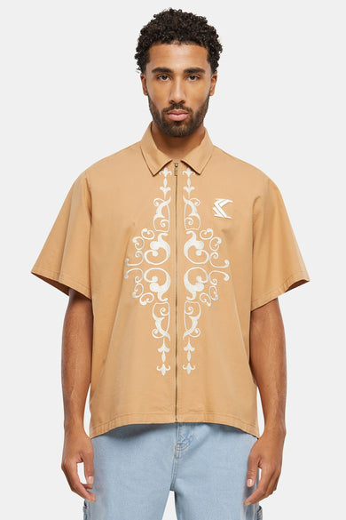 Beige overhemd met korte mouwen van Karl Kani, met een verticale broderie en een ritssluiting.