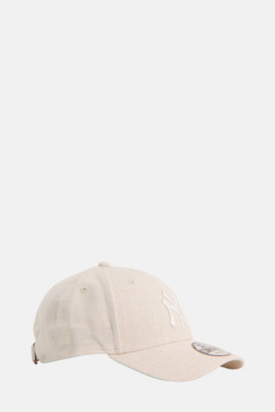 Beige pet van New Era met geborduurde logo en verstelbare sluiting, zijaanzicht.
