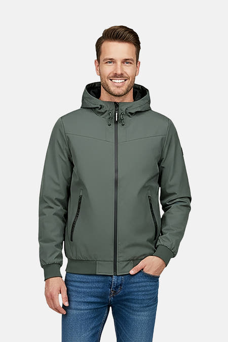 Groene korte jas van Cars, met capuchon en zwarte ritssluiting, gedragen met een blauwe jeans.
