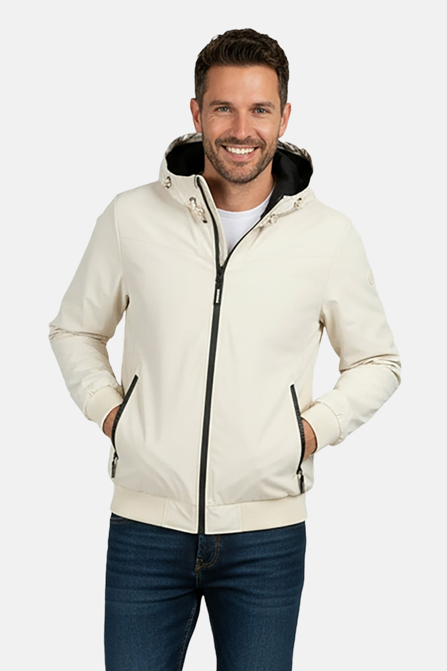 Beige, korte jas van Cars met capuchon en zwarte rits gedragen over een wit shirt en jeans.