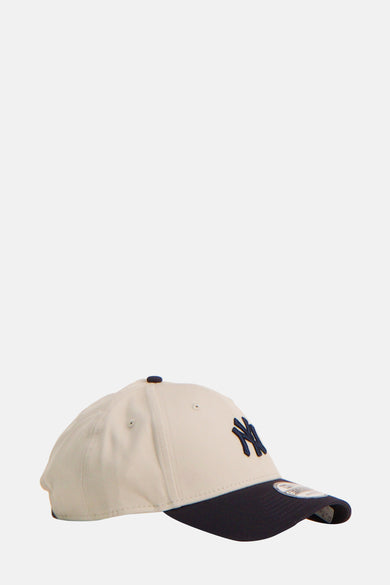 Multikleurige pet van NEW ERA, met donkerblauwe klep en geborduurd logo aan de zijkant.