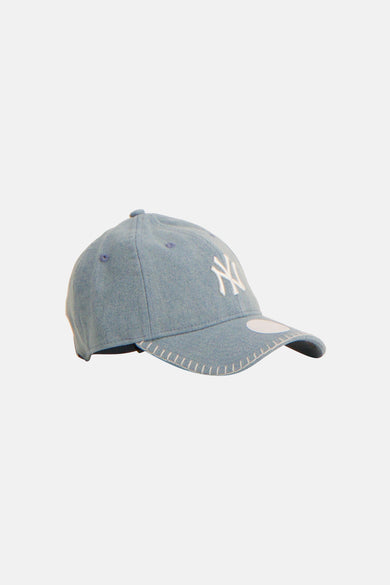 Blauwe pet van NEW ERA met witte geborduurde logo en sierstiksels op de klep.